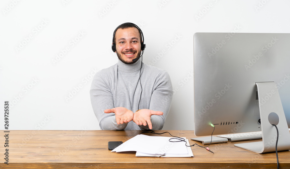 Telemarketer Colombian man holding copyspace imaginary on the palm to insert an ad