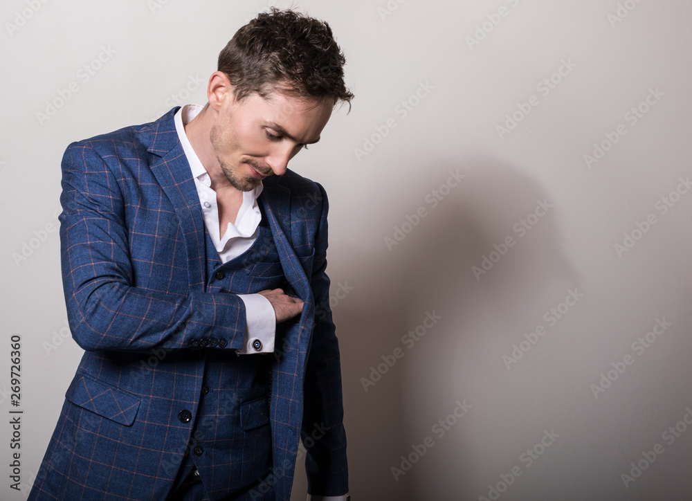 Elegant young handsome man in stylish blue costume. Studio fashion portrait.
