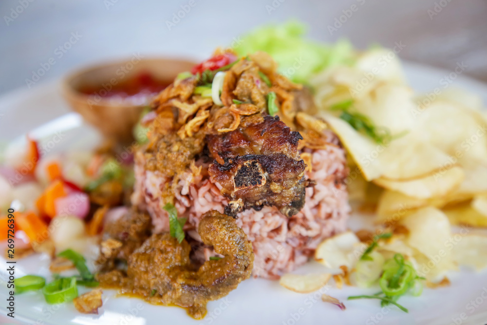 Rice and beef meat served with chips and green salad, casual dining restaurant food