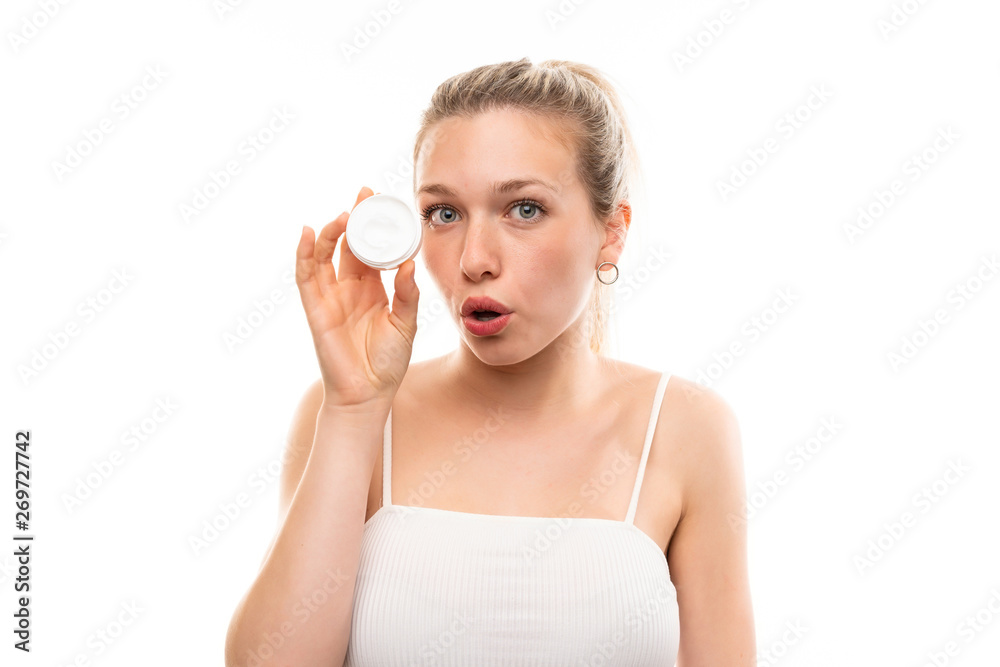Young blonde woman over isolated white background with moisturizer Young blonde woman over isolated white background with moisturizer