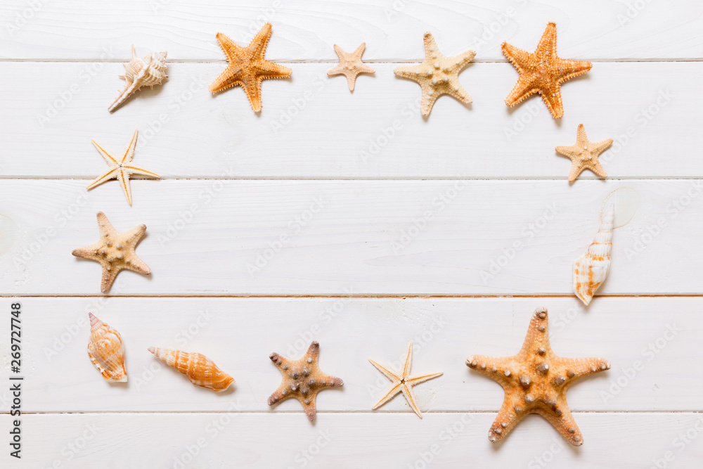 Flat lay of various seashell and starfish on white wooden table, top view. Copy space background, summer concept Flat lay of various seashell and starfish on white wooden table, top view. Copy space background, summer concept