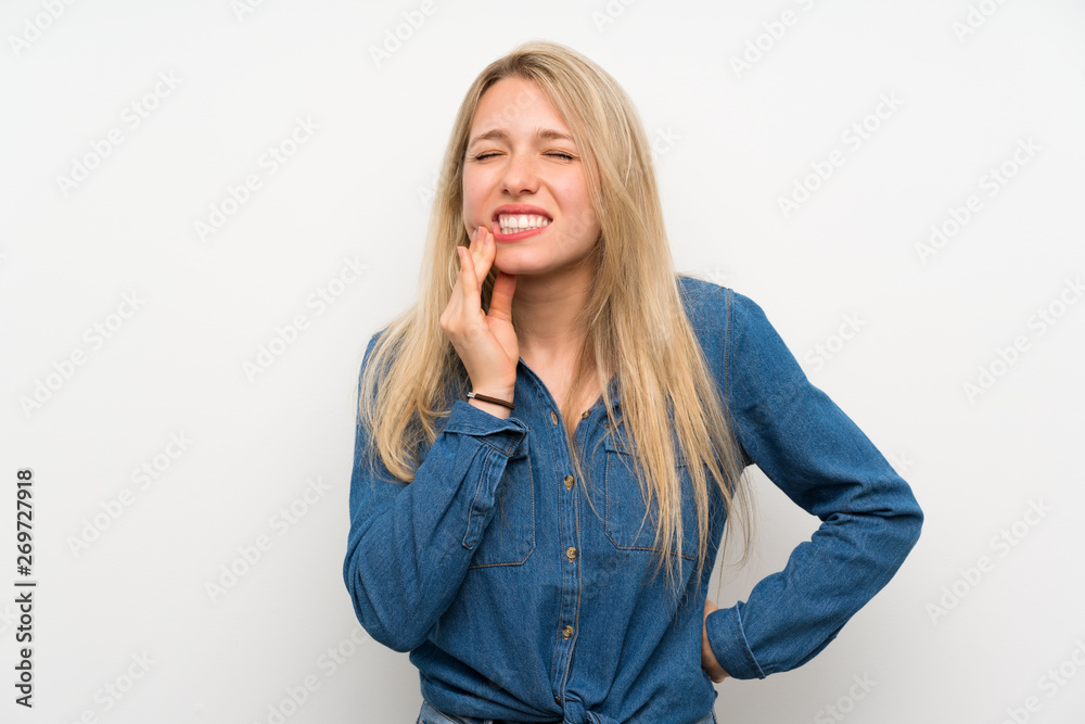 Young blonde woman over isolated white wall with toothache Young blonde woman over isolated white wall with toothache
