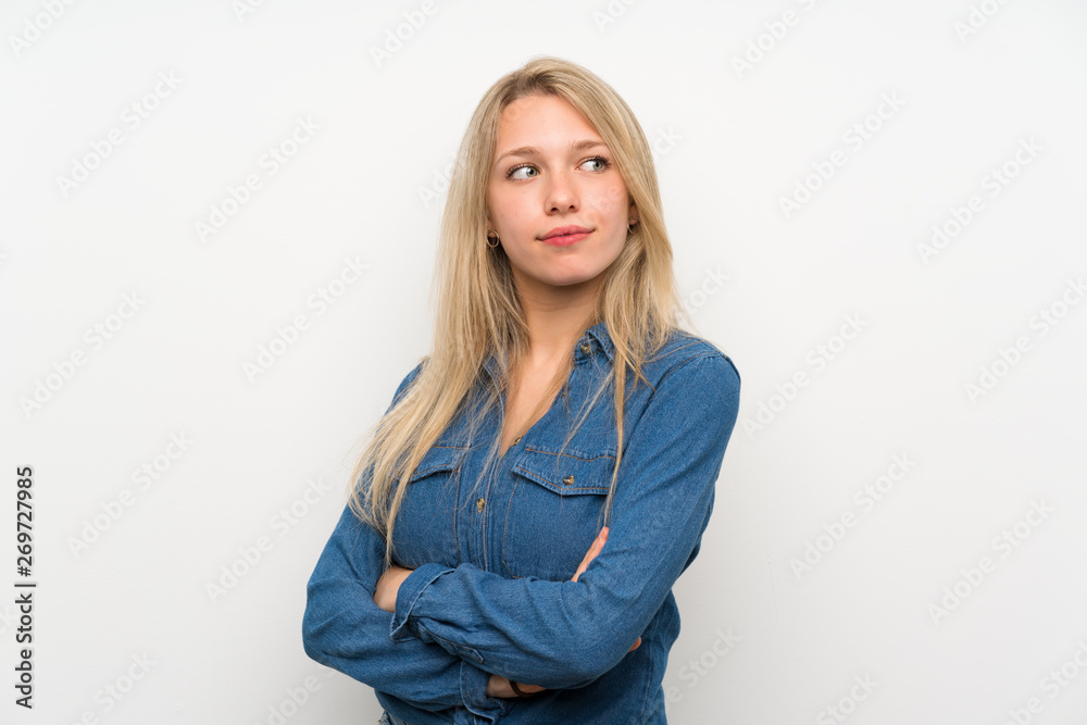 Young blonde woman over isolated white wall portrait Young blonde woman over isolated white wall portrait