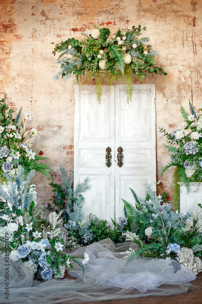 Naklejka premium Flower decoration. Wedding decor. Flower interior composition in the studio. Spring photo zone. White doors.