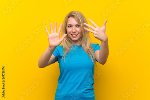 Young blonde woman over isolated yellow background counting nine with fingers