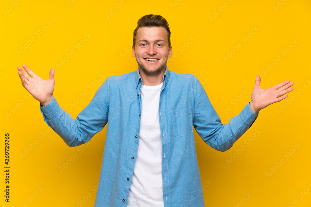 Blonde handsome man over isolated wall with surprise facial expression Blonde handsome man over isolated wall with surprise facial expression
