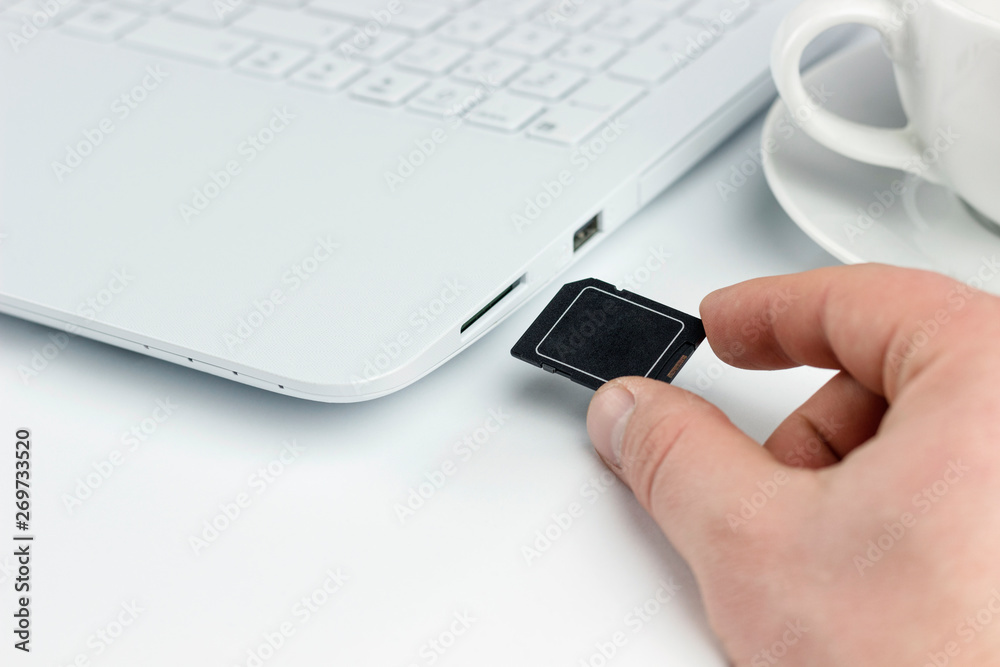 insert sd card in laptop, hand with sd card next to a sd card slot in a  laptop Stock Photo | Adobe Stock