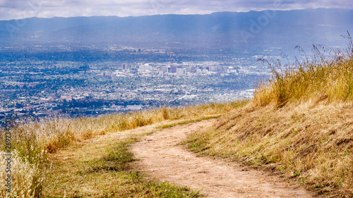 Hiking trail on the hills of South San Francisco bay area  aerial view of downtown San Jose visible in the background  California