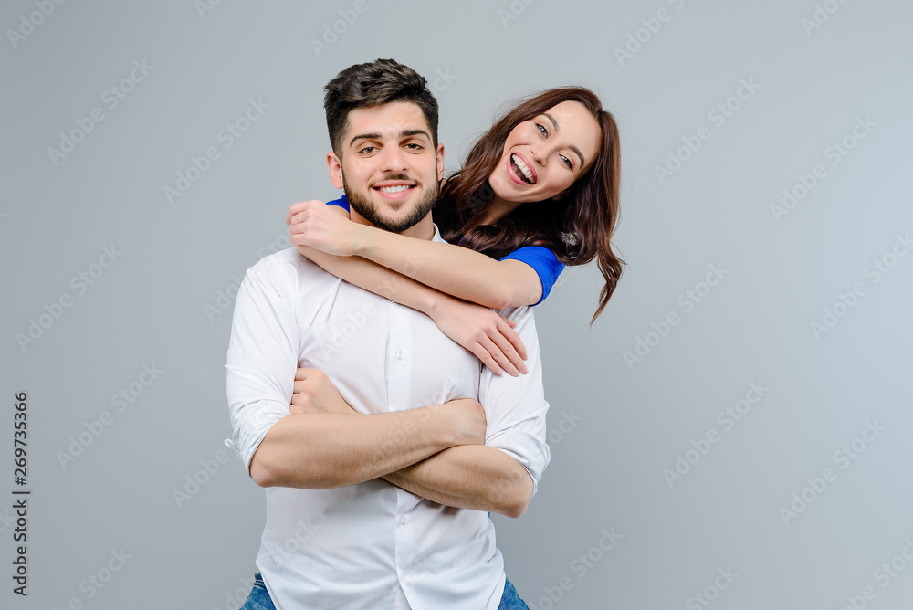 Attractive couple smiling and laughing isolated over grey background Attractive couple smiling and laughing isolated over grey background