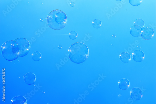 Many large soap bubbles flying in blue sky  city magic