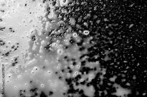 Spilled milk puddle with droplets isolated on black background and texture  top view