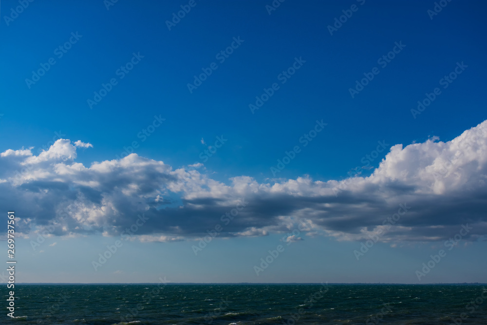 Clouds over water. Clouds against a blue sky. Blue sky with clouds on a sunny day.