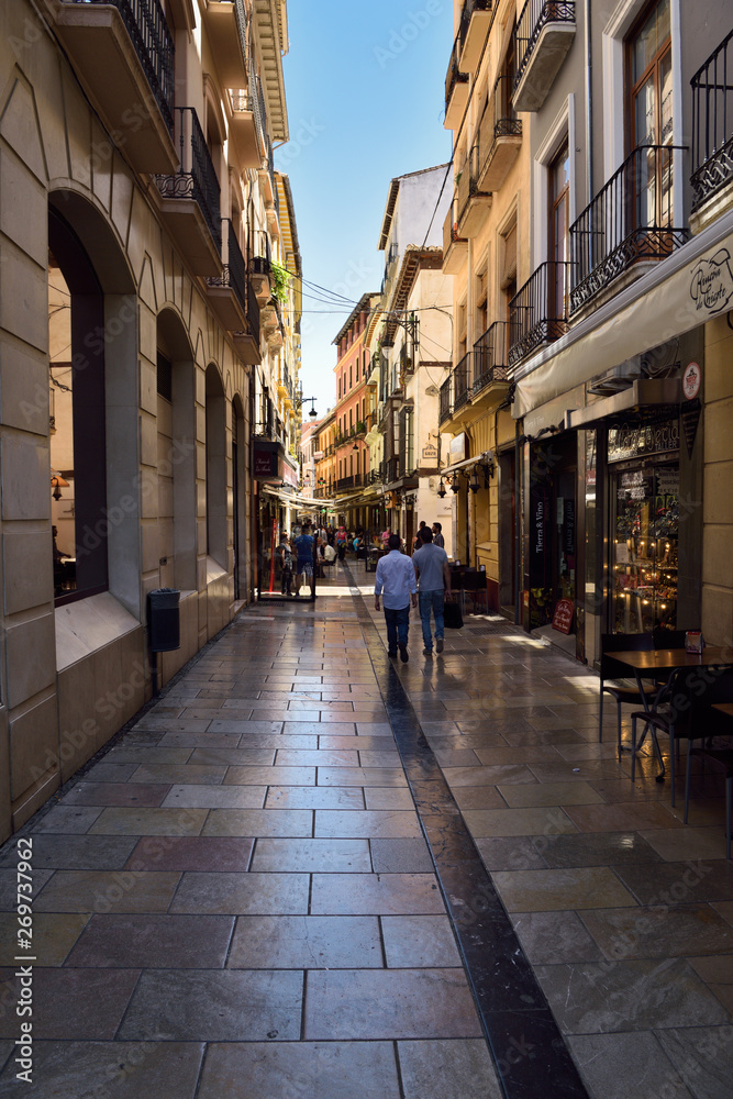 Pedestrians walking down Navas street to shops and restaurants in Granada Spain