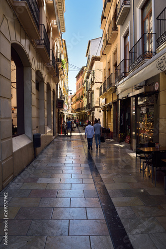 Fototapeta Naklejka Na Ścianę i Meble -  Pedestrians walking down Navas street to shops and restaurants in Granada Spain