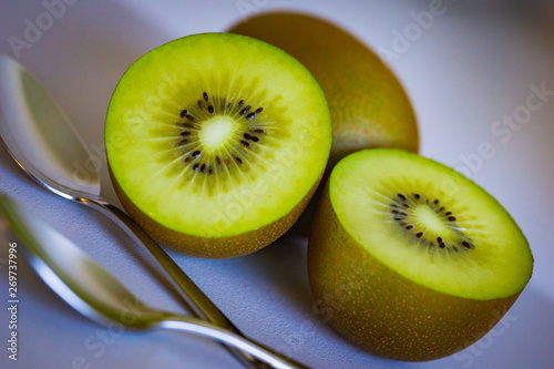 close up of half cutted kiwifruits from New Zealand. Background of fresh and juicy golden green kiwis for healthy smoothies