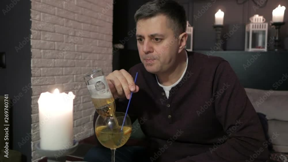 Drunk man continues to drink a cocktail. Loneliness and booze. Bachelor Drunk man continues to drink a cocktail. Loneliness and booze. Bachelor