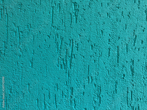 decorative concrete wall, painted in cyan green. painted cement on the wall.