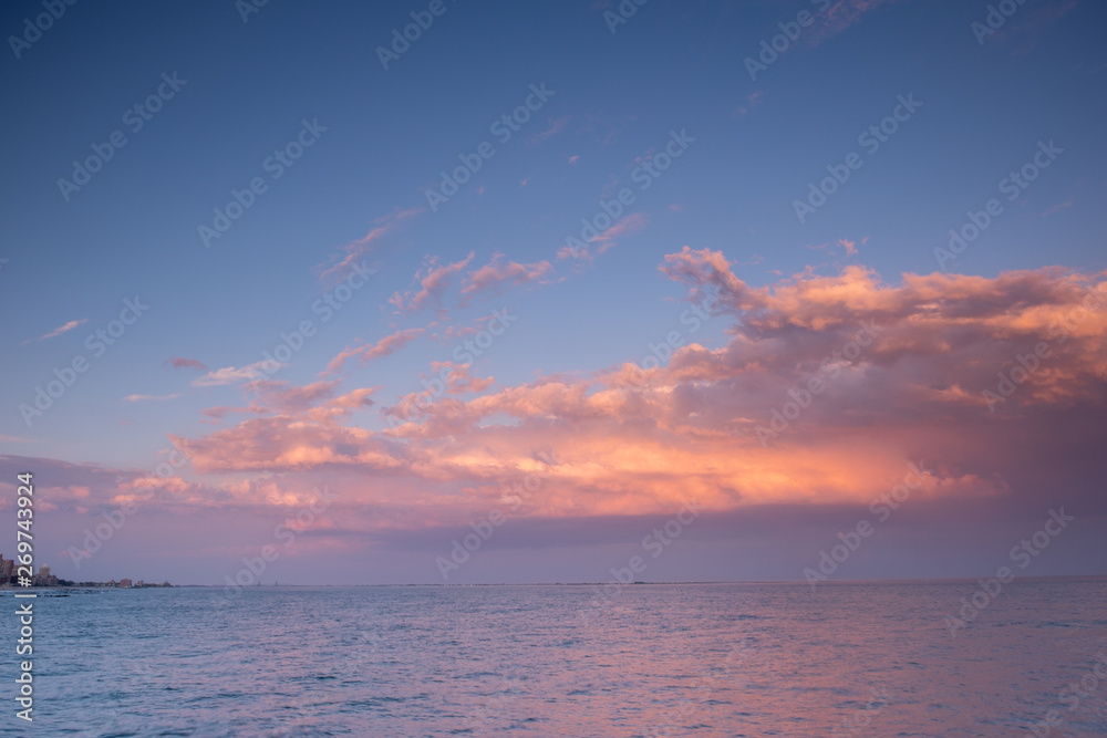 Sunset clouds with pink light and blue sky
