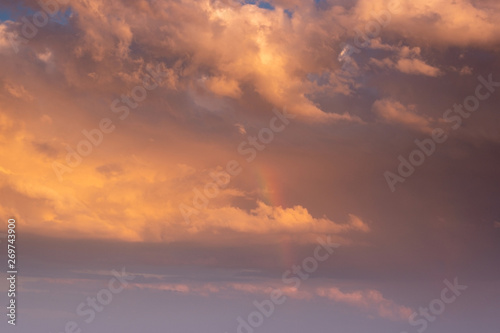 Sunset clouds with orange light and rainbow