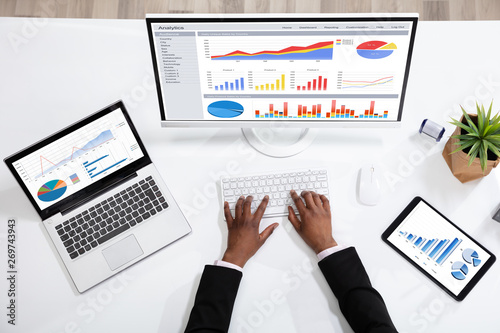Businessperson Analyzing Statistics On Computer Screen