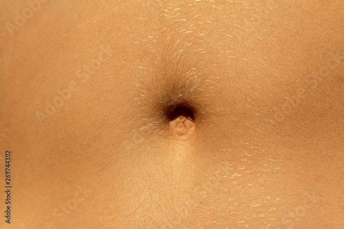 Closeup - navel of the stomach - belly button. Slim nude young woman belly. photo