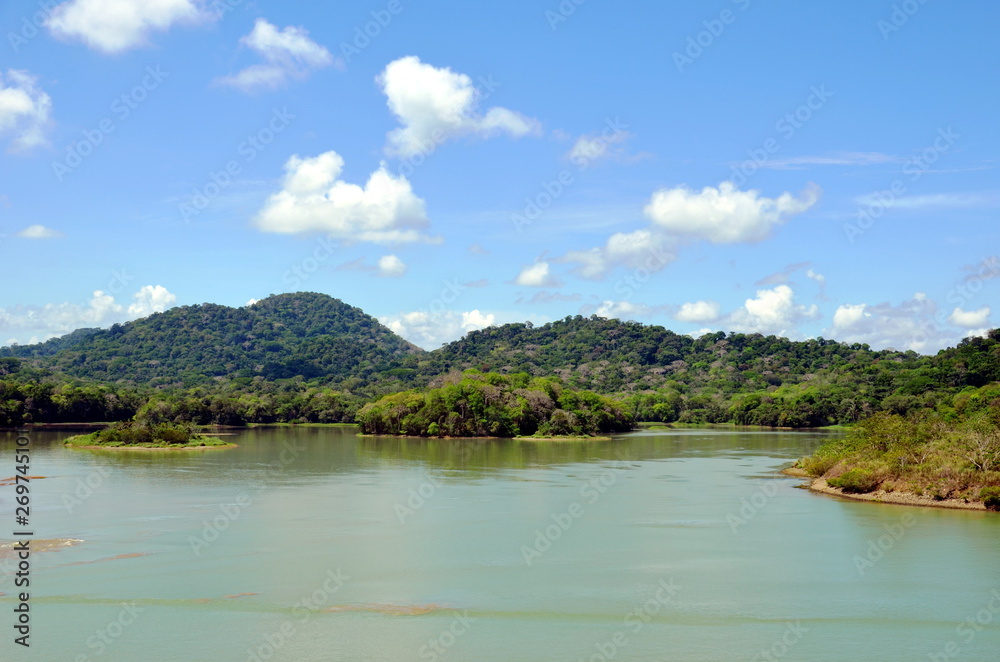 Green landscape of the Panama Canal, view from transiting container ship.