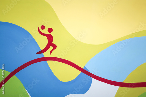 A man with a ball painted on a colored wall