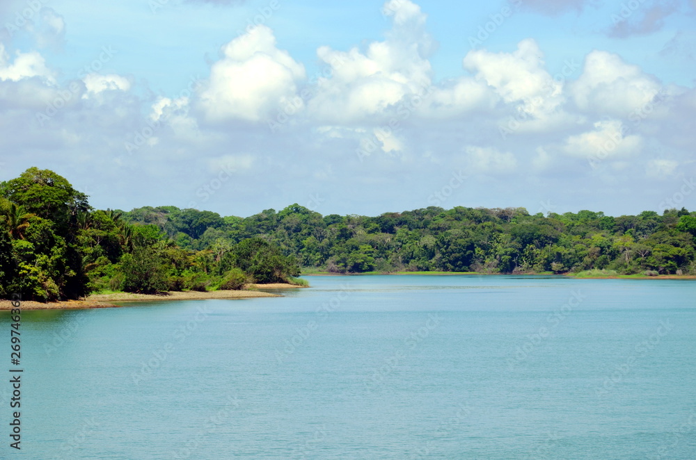 Green landscape of the Panama Canal, view from transiting container ship.