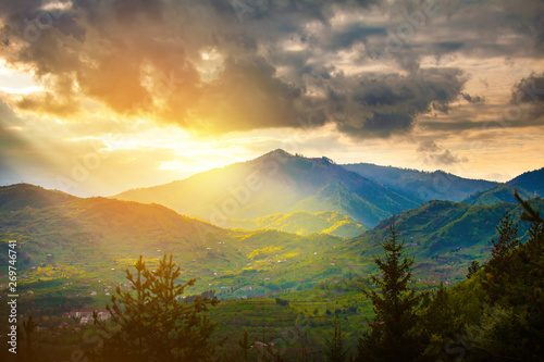 Sun rays beams over rural mountain resort epic landscape