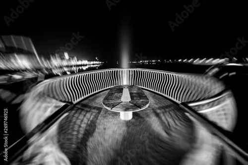 Dynamic view of an illuminated architecture bridge over a river during the night photo