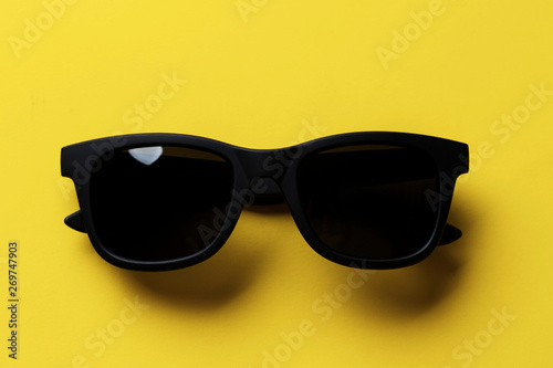 black sunglasses on a yellow background.