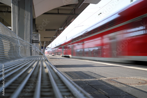 Menschenleerer Bahnsteig und ausfahrender Nahverkehrszug - Stockfoto