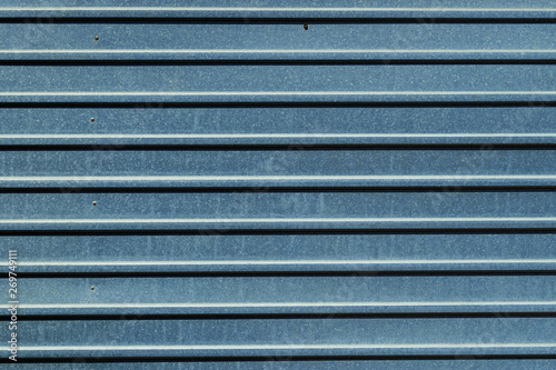 Texture of a gray metal fence. Metal fencing with parallel lines