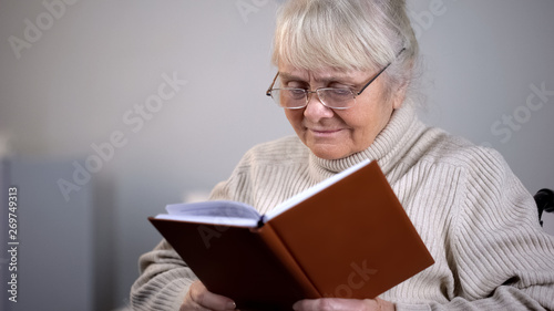 Senior lady eyeglasses reading book, pension leisure, free time hobby, education