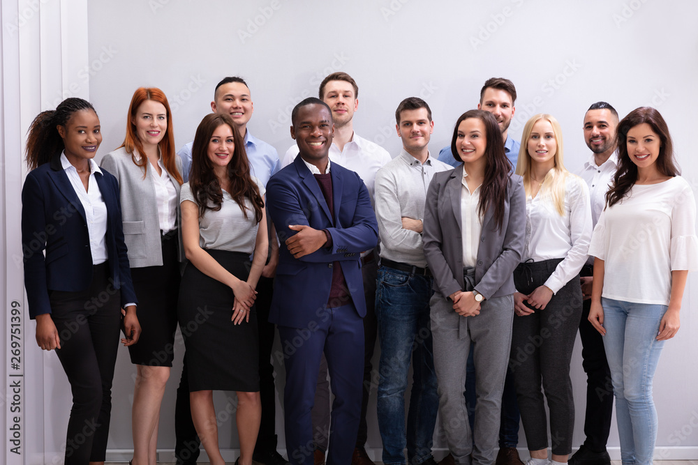 Group Of Smiling Businesspeople Standing In Office
