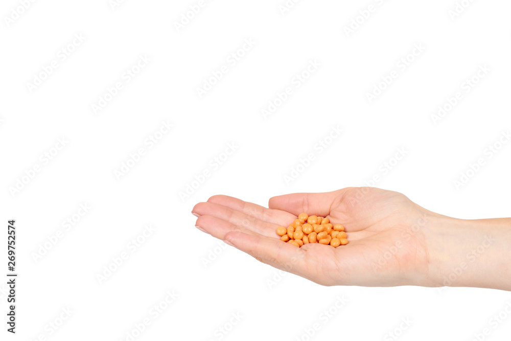 Hand with orange pills, medical care and help, chemical vitamins.