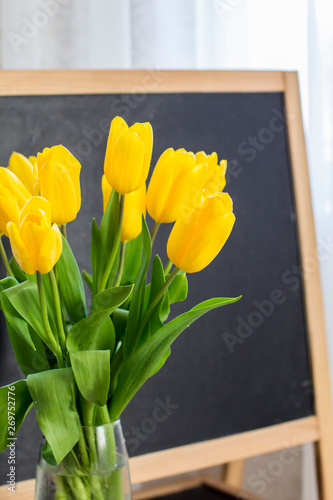A bouquet of yellow tulips on a blackboard background