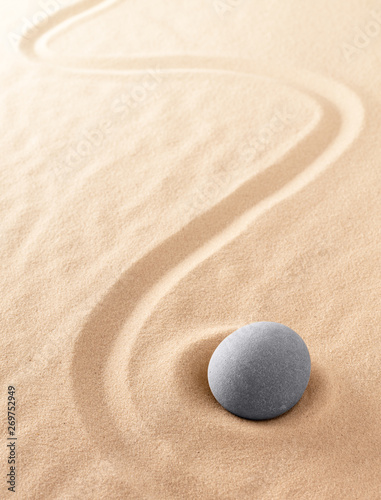 Zen meditation stone to focus and concentrate for a quiet peace of mind. Spiritual raked sand background texture. Concept for harmony purity and spirituality. .