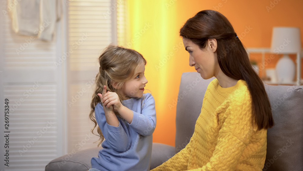 Cute preschool girl telling happy mommy funny stories and laughing, having fun Cute preschool girl telling happy mommy funny stories and laughing, having fun