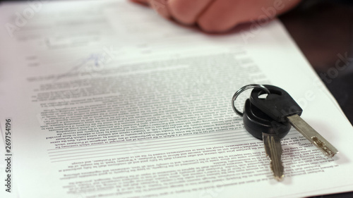Car keys on contract page closeup, transportation rent agreement, legal deal