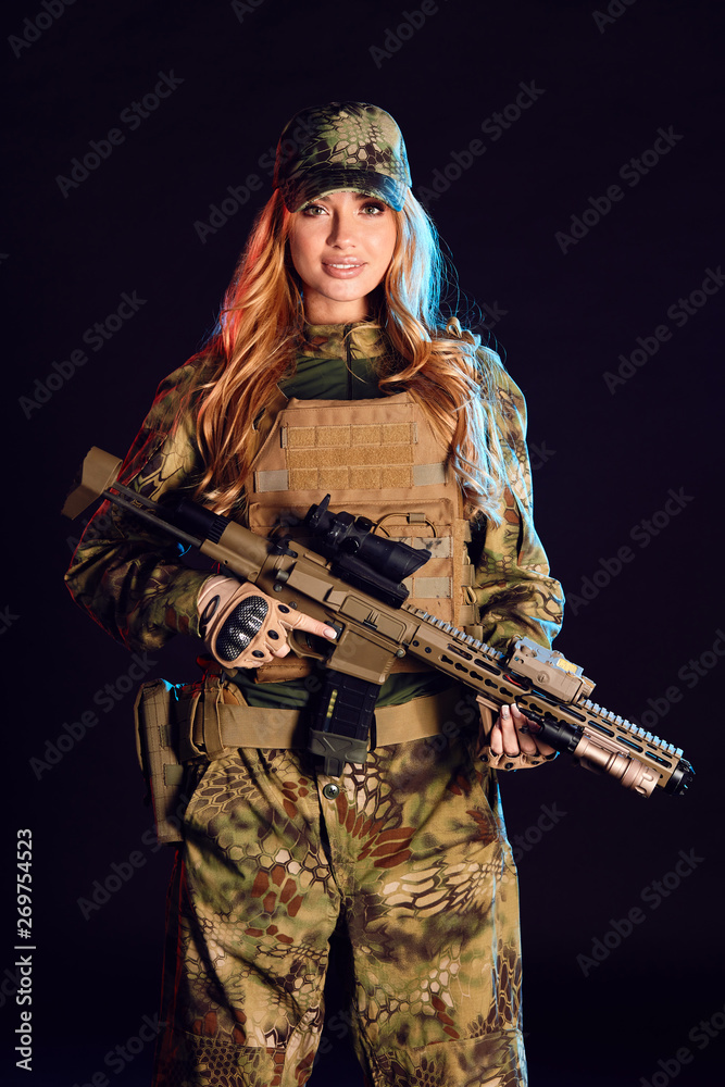 Sniper woman in ghillie suit, cap and plate carrier holds airsoft rifle  over black background Stock Photo | Adobe Stock