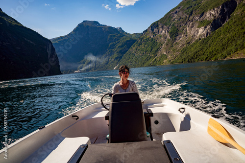 Woman driving a motor boat. Geiranger fjord, Beautiful Nature Norway.Summer vacation.