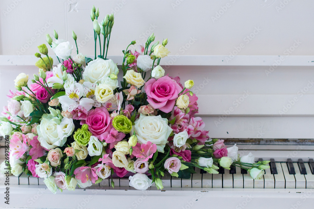 Bouquet of flowers. Flower Arrangement: Roses, Eustomas, Alstroemeria on the Piano