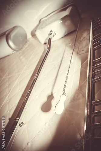 White toilet cistern of the old design. Chain with ceramic handle to drain water in the toilet. Retro toned photo.