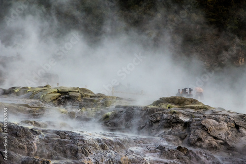 A walk through a geothermal park in Rotorua, New Zealand with tourists in the fog