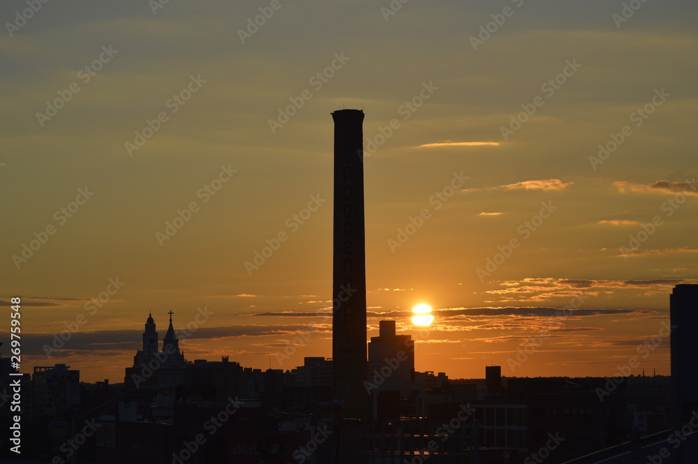 Sunset over Philadelphia with factory chimney and a church outline