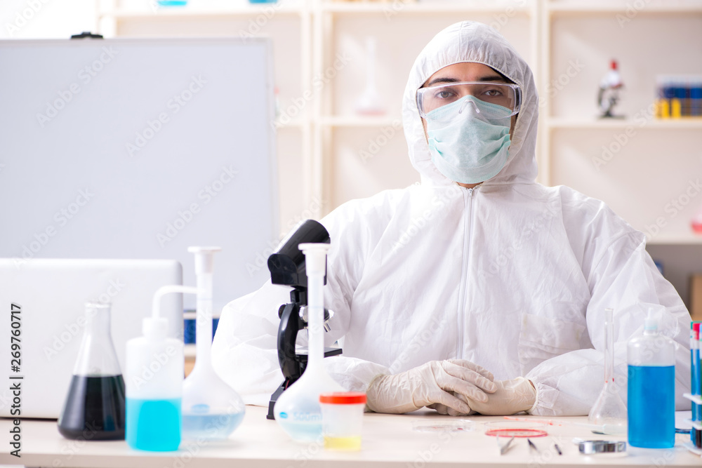 Young handsome chemist working in the lab Young handsome chemist working in the lab