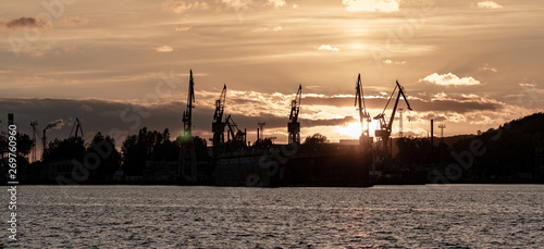 A beautiful view of the shipyard during sunset. Crane and sea