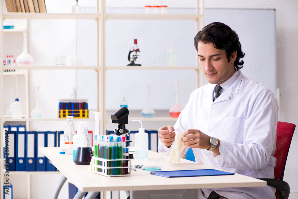 Young handsome chemist working in the lab Young handsome chemist working in the lab