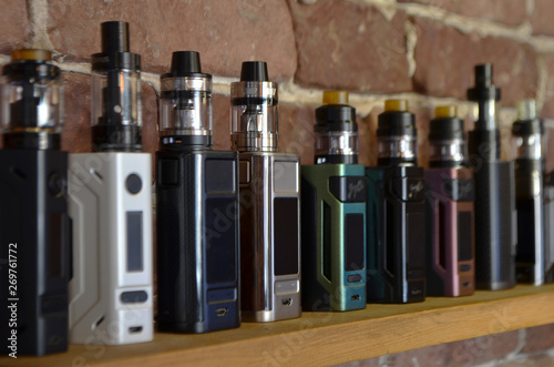 Electronic cigarette on a background of vape shop. E-cigarette for vaping. Popular vape devices